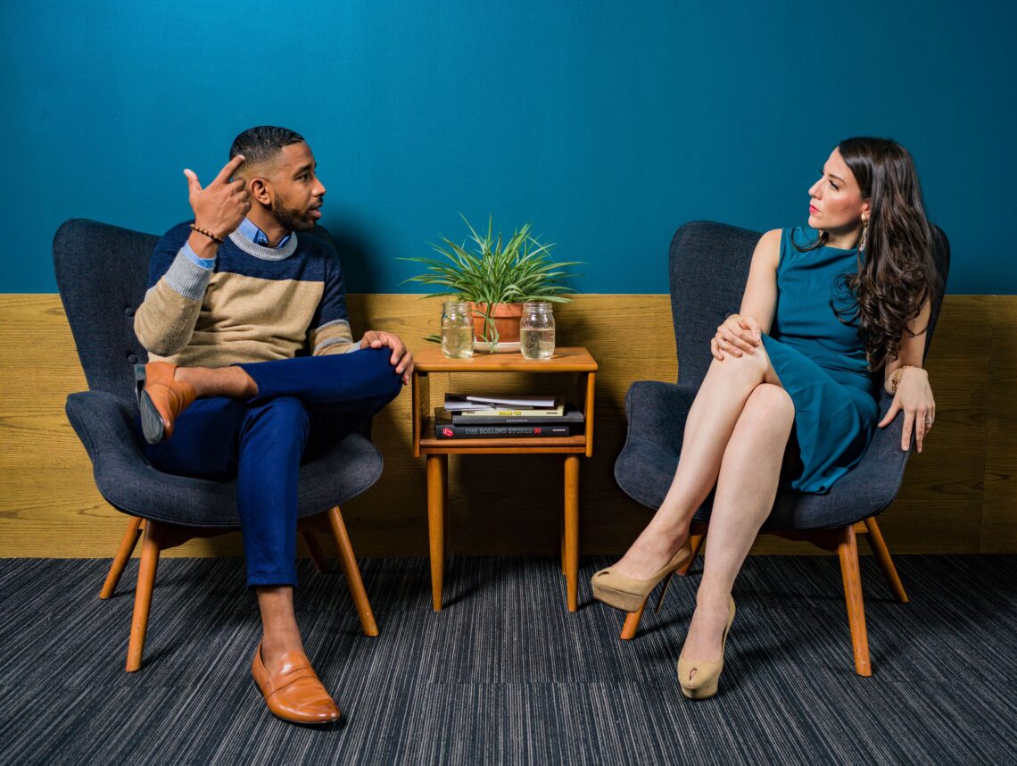 Two people sitting in chairs having a conversation