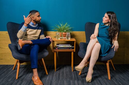 Two people sitting in chairs having a conversation