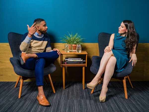 Two people sitting in chairs having a conversation