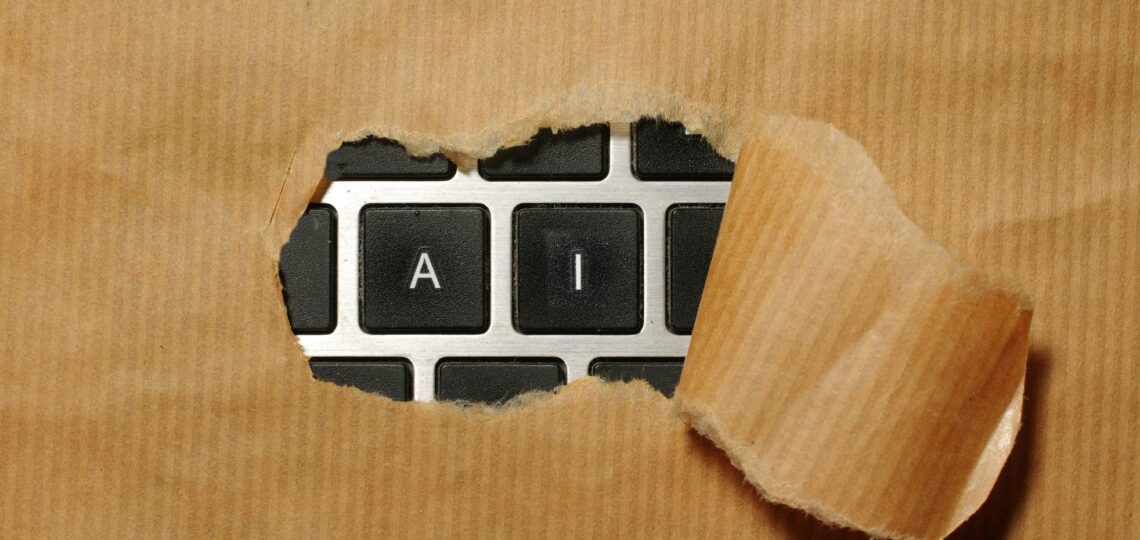 A keyboard with paper over the keys peeling back to reveal only the letters AI.