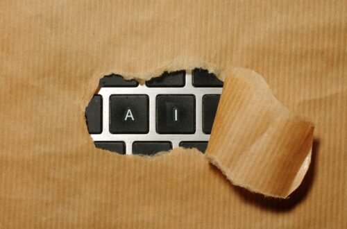 A keyboard with paper over the keys peeling back to reveal only the letters AI.