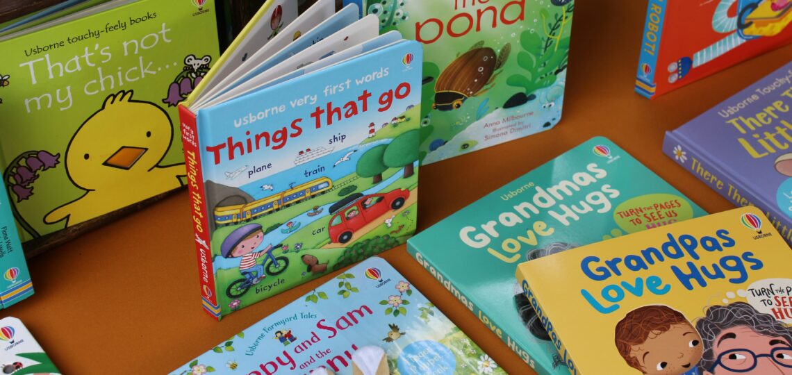Multiple children's books stacked on a table.