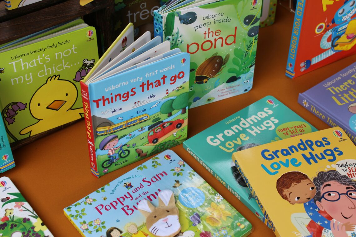 Multiple children's books stacked on a table.