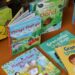 Multiple children's books stacked on a table.