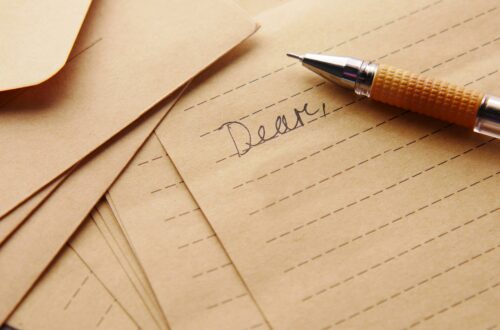 A letter with the word "Dear," written at the top of the paper accompanied by an old ink pen.