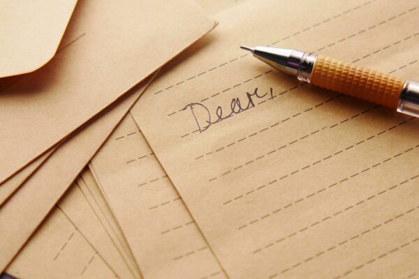 A letter with the word "Dear," written at the top of the paper accompanied by an old ink pen.
